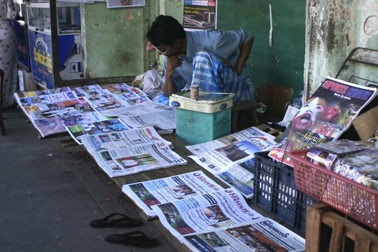Lesender Zeitungsverkäufer in Myanmar